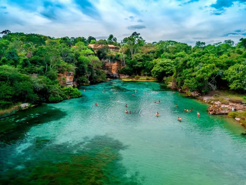 piscina natural cristalina cercado de vegetação natival com algumas pessoas nadando na Chapada Diamantina, Bahia