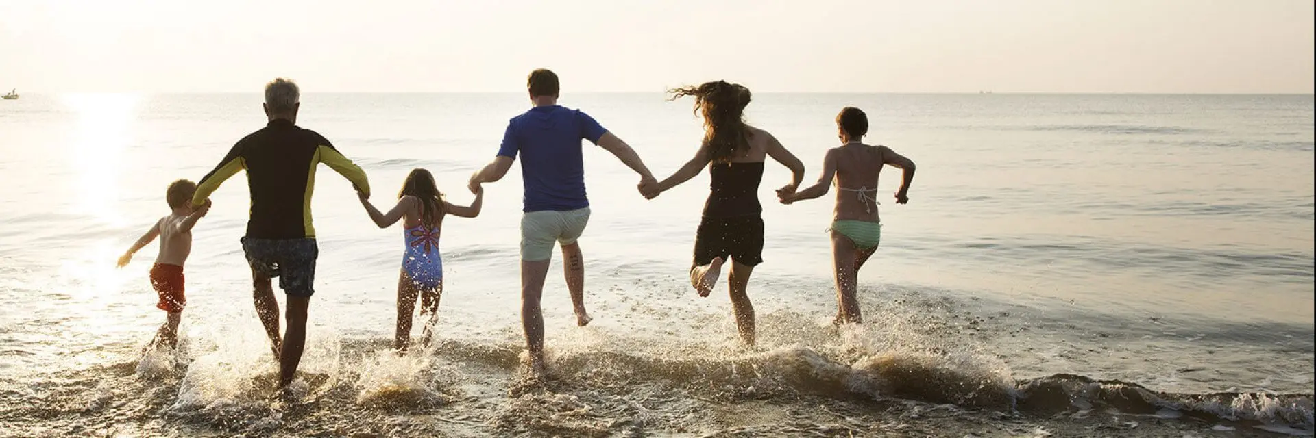 Imagem de uma família pulando no mar