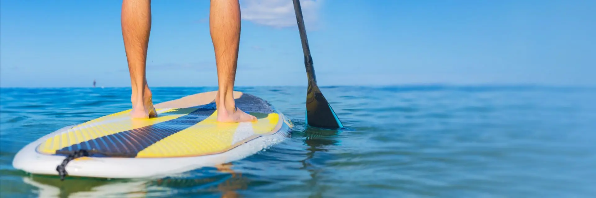 Imagem de uma pessoa praticando stand up paddle