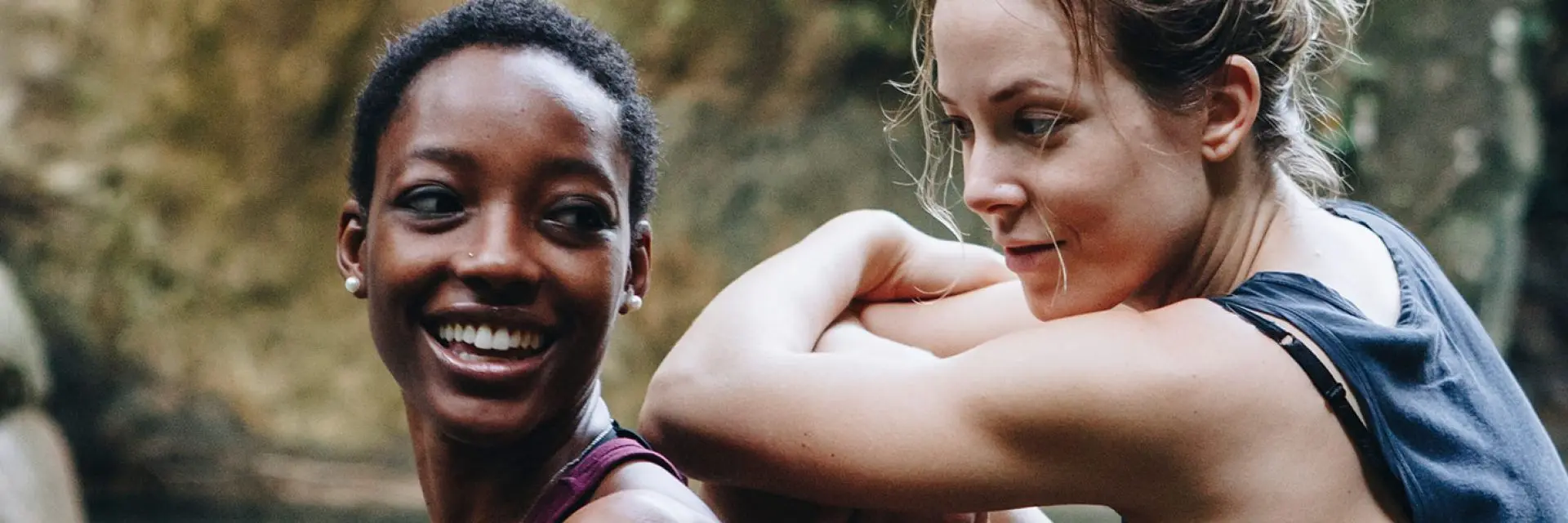 Imagem de duas mulheres sentadas em meio a natureza