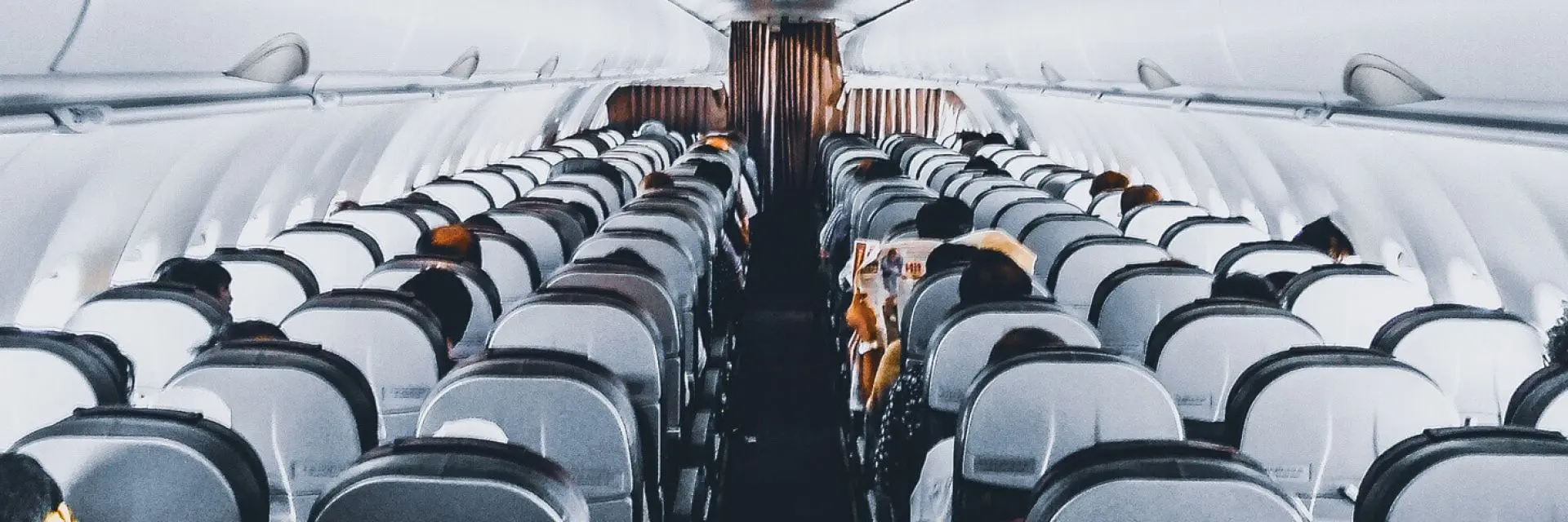 Imagem da parte interna de um avião com os assentos