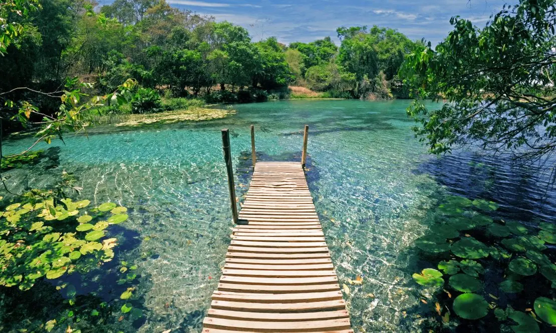 pequena ponte de madeira que leva até um lago de águas cristalinas na Chapada Diamantina, Bahia