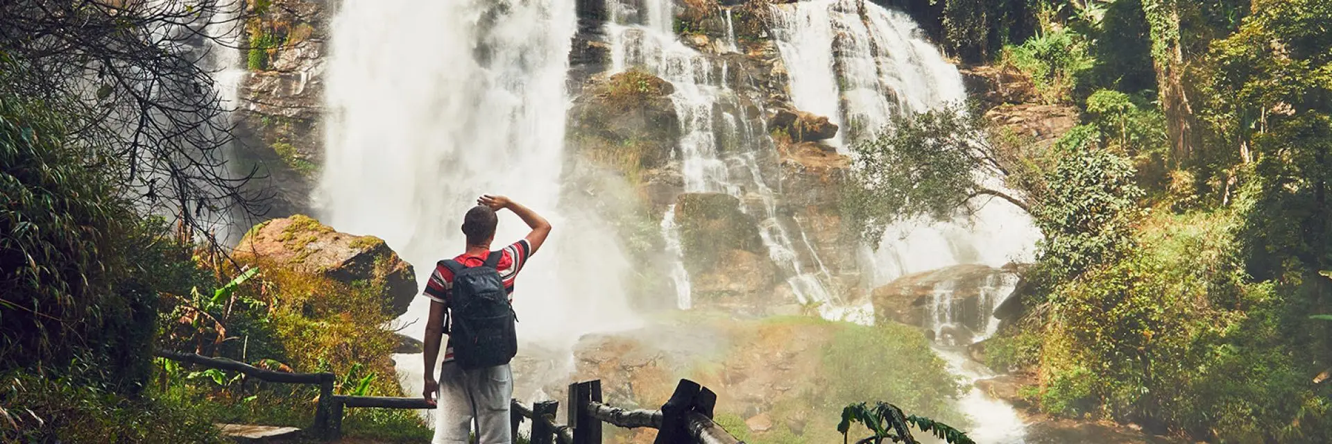 Imagem de um homem observando uma cachoeira